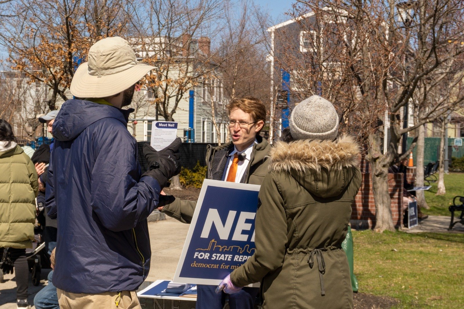 Neil talking with neighbors at a park signup table